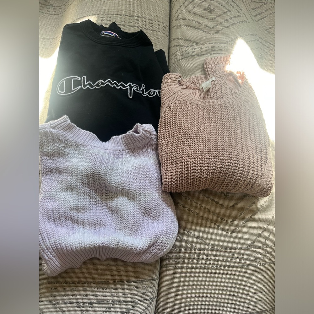 One champion crew neck, purple tie up sweater, and pink oversized sweater.
